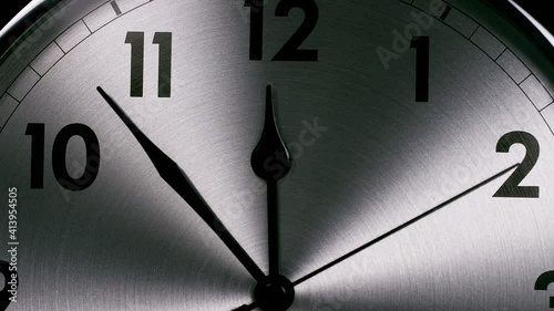 Camera zooms into a clock face as the hands whizz around towards 12 o'clock