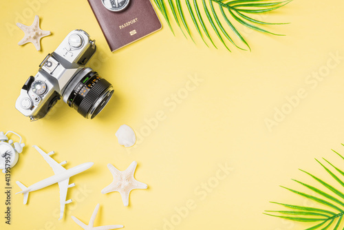 Flat lay top view mockup retro camera films, airplane, passport, starfish traveler tropical beach accessories on a yellow background with copy space, Vacation summer travel and business trip concept