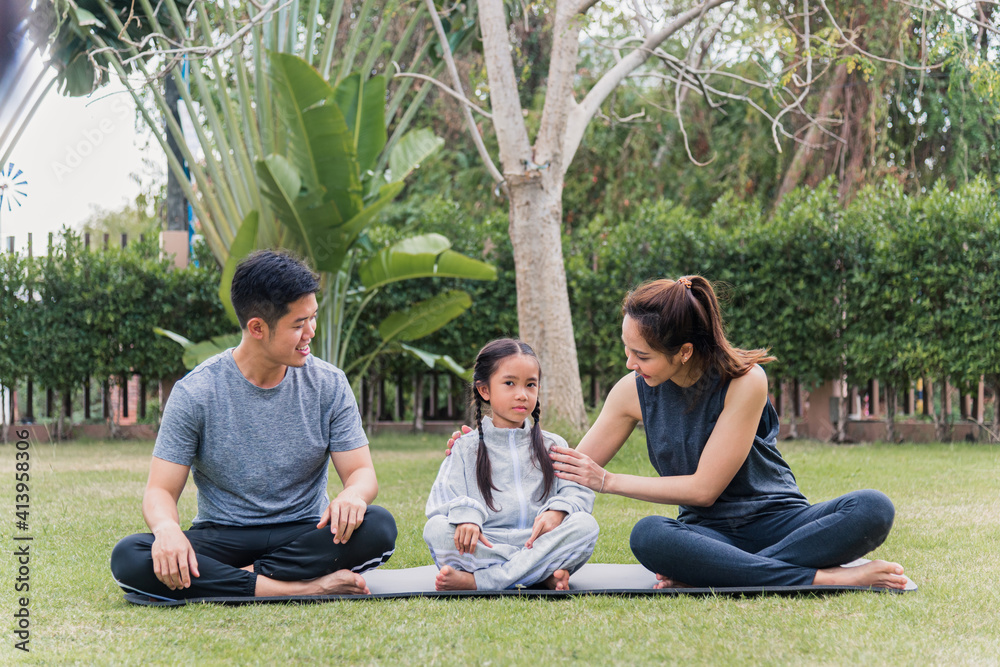 Asian young mother, father practicing doing yoga exercises with child daughter outdoors in meditate pose together in nature a field garden park, family kid sport and exercises for healthy lifestyle