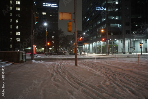 Photography Urban cityscape during night time with city streets during snowstorm in the wint