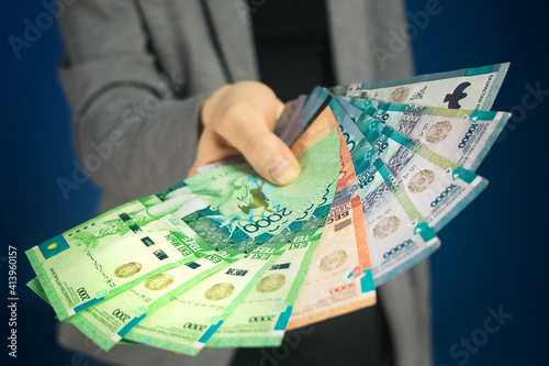 Tenge National currency of Kazakhstan in hand. Close-up, selective focus.