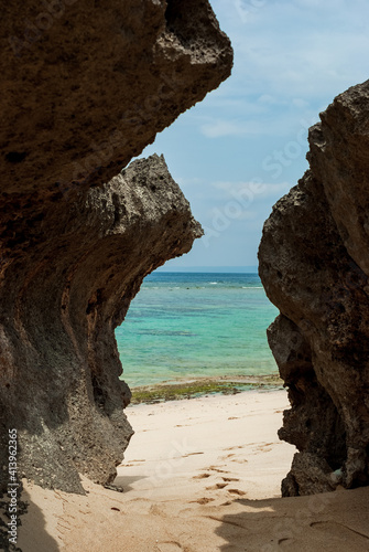 沖縄県今帰仁村の岩の間から海につながる砂浜の道