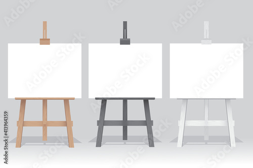 Wooden easel stand with blank canvas on white background