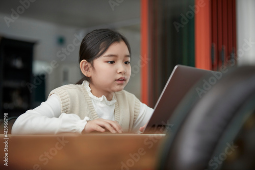 at home schoolgirl do homework, focused little Asia girl watch video lesson using laptop app, interested in on-line web virtual class studying from at home, homeschooling concept