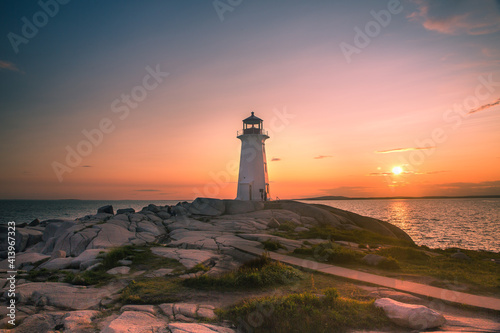 A dramatic sunset at Peggy's Cove Lighthouse Atlantic Coast Nova Scotia Canada. The most visited tourist location in the Atlantic Canada and famous Lighthouse captured with vibrant colors during sunse