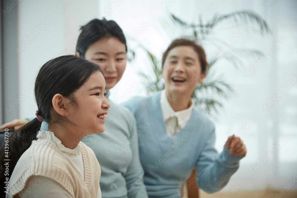 Little kid daughter and old mother while sitting on sofa at home Little kid daughter and old mother while sitting on sofa at home