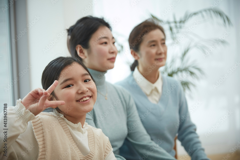 Little kid daughter and old mother while sitting on sofa at home Little kid daughter and old mother while sitting on sofa at home