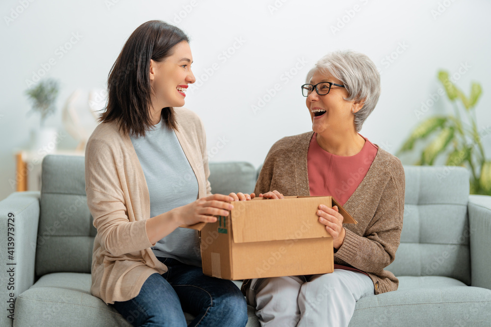 women are holding cardboard box women are holding cardboard box
