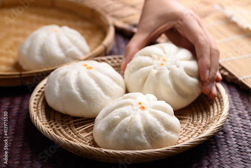 Steamed buns stuffed with minced pork holding by hand, Asian food © nungning20