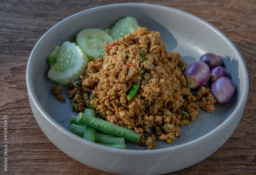 Southern Stir-Fried Pork with Yellow Curry Paste Served with Purple eggplant, Cucumber and Yard long bean. Selective focus. Southern Stir-Fried Pork with Yellow Curry Paste Served with Purple eggplant, Cucumber and Yard long bean. Selective focus.