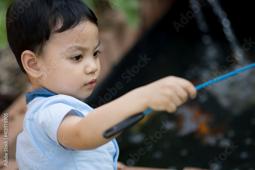 Portrait of Asia boy playing at koi pond