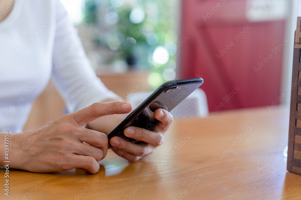 Close up hands of beautiful young woman holding mobile, smart phone sitting in cafe. Soft focus hands of women holding and use cell phone in coffee shop. Tectechnology and lifestyle concept. Close up hands of beautiful young woman holding mobile, smart phone sitting in cafe. Soft focus hands of women holding and use cell phone in coffee shop. Tectechnology and lifestyle concept.