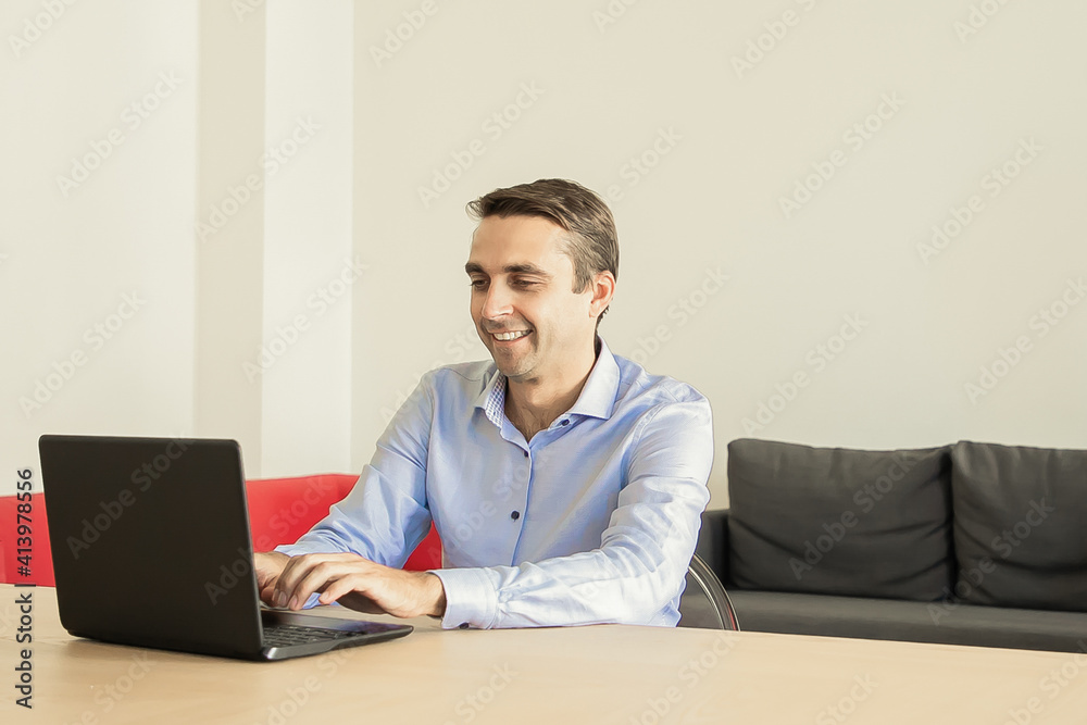 Smiling dad sitting at table and typing on laptop. Little children playing on sofa with pillow on background. Caucasian father with kids during quarantine. Childhood and digital technology concept Smiling dad sitting at table and typing on laptop. Little children playing on sofa with pillow on background. Caucasian father with kids during quarantine. Childhood and digital technology concept