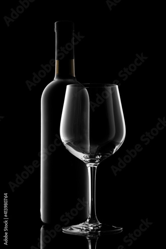 red wine bottle and wine glass isolated on black background