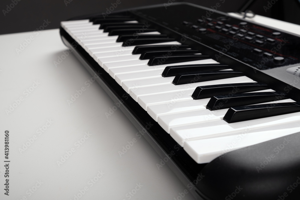 Naklejka premium synthesizer on a white table,musical instrument closeup