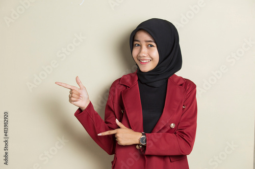 Young asian business woman wearing hijab smiling confident pointing with fingers to different directions. Copy space for advertisement
