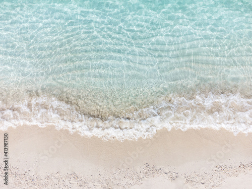 Aerial top view of beautiful tropical white sand beach with wave foam and transparent sea, Summer vacation and Travel background with copy space, Top view from drone