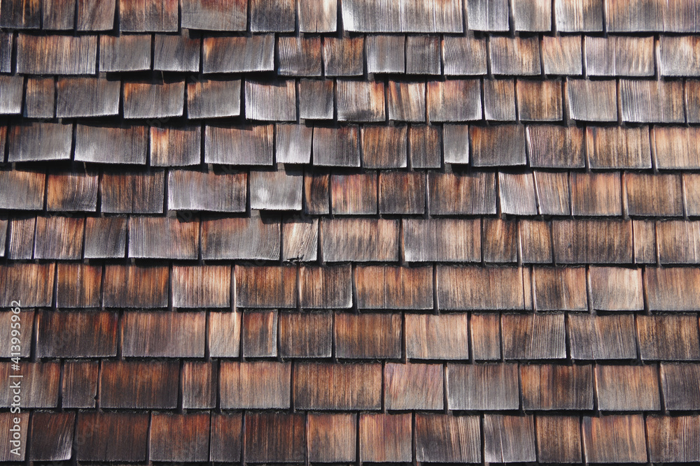 Close-up full frame view of a section of wood shingle siding of a building Close-up full frame view of a section of wood shingle siding of a building