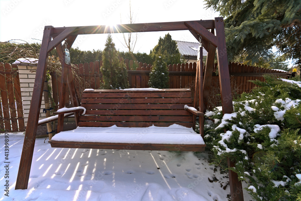 wooden swing covered with snow wooden swing covered with snow