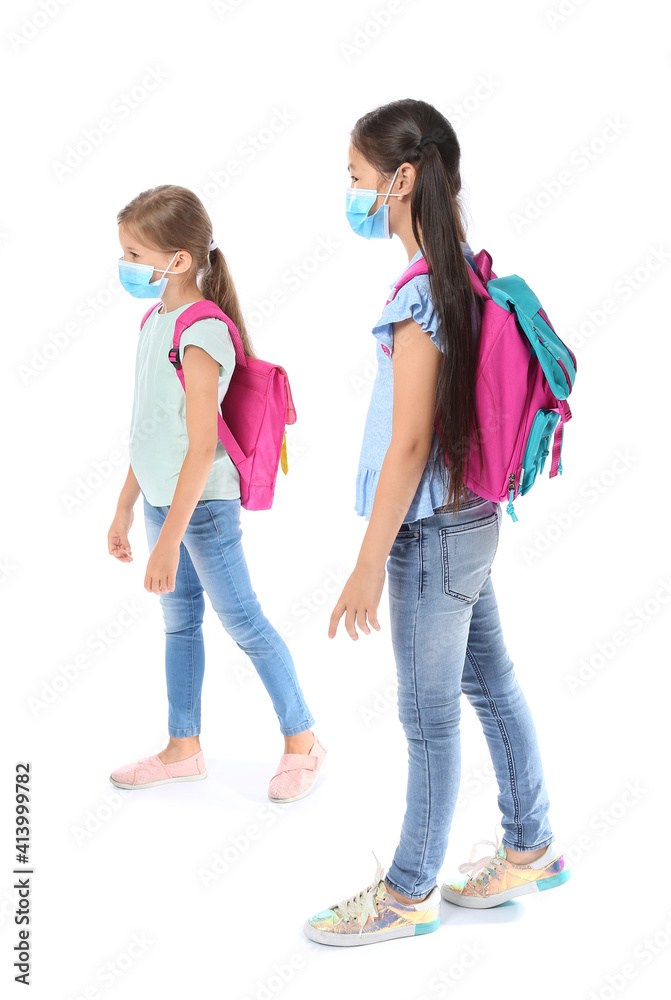 Little schoolchildren in medical masks on white background. Coronavirus epidemic Little schoolchildren in medical masks on white background. Coronavirus epidemic