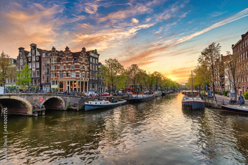 Fototapeta premium Amsterdam Netherlands, sunset city skyline of Dutch house at canal waterfront