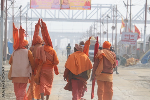 Allahabad, Uttar Pradesh India- February 09 2021: A team of Hindu Sadhus wearing saffron clothes walking on the pilgrim route to holy Sangam.