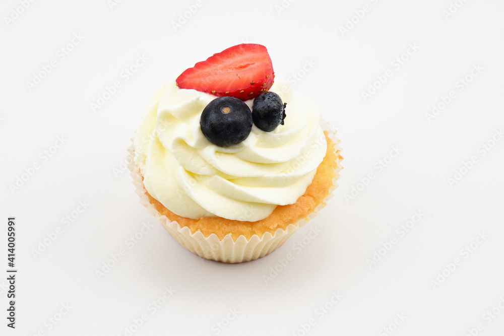Pastry tartlet with custard, two blueberries and half strawberry isolated on white background Pastry tartlet with custard, two blueberries and half strawberry isolated on white background