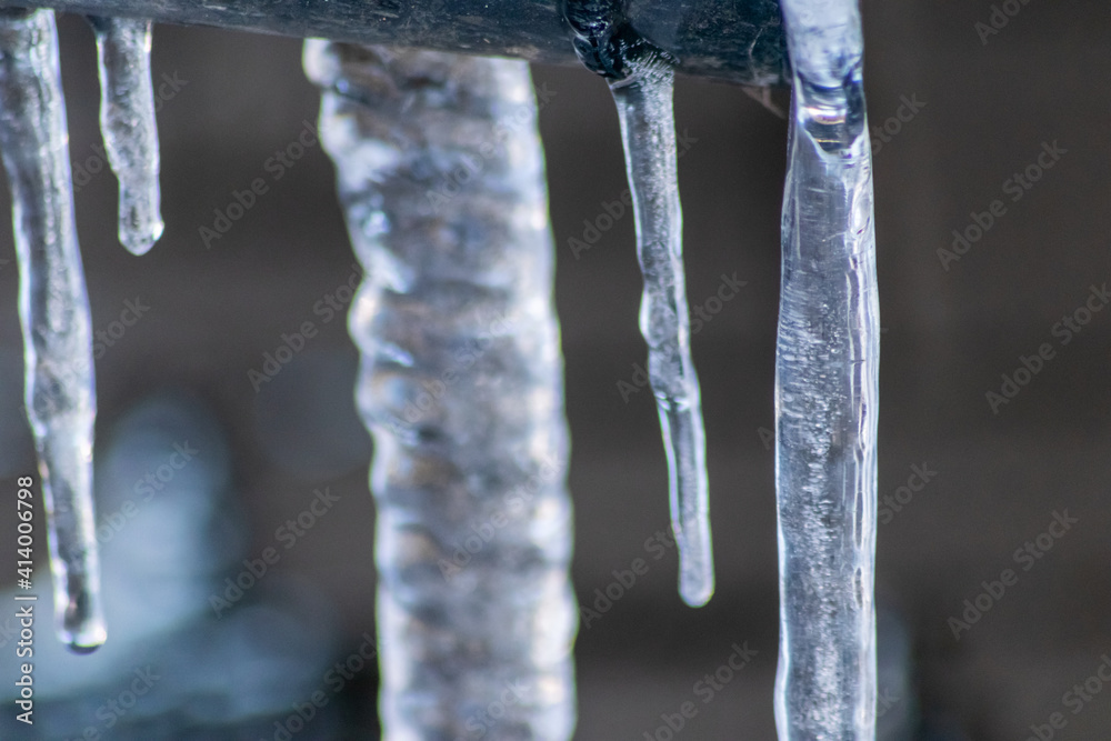 Long icicles melting in winter and spring from December to January as frozen water with frosty ice as slippery crystals on urban streets and beautiful winter scenery show need for weather insurance Long icicles melting in winter and spring from December to January as frozen water with frosty ice as slippery crystals on urban streets and beautiful winter scenery show need for weather insurance