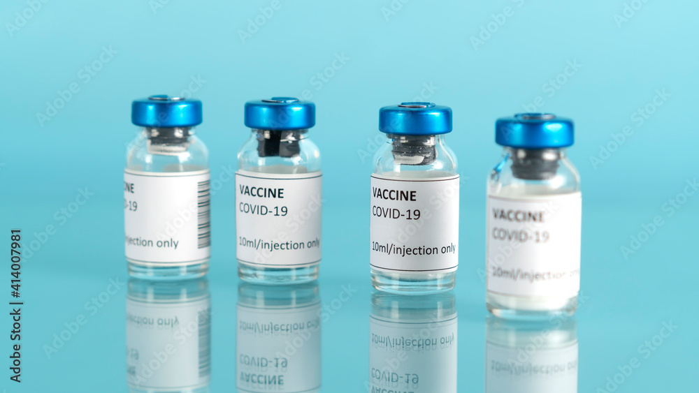 Coronavirus vaccine vial. Covid vaccination with vaccine glass bottles. Blue medical background. Selective focus. Coronavirus vaccine vial. Covid vaccination with vaccine glass bottles. Blue medical background. Selective focus.