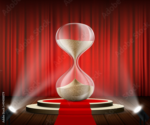 Hourglass on a round podium against the of a red curtain