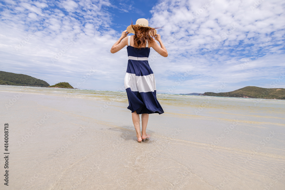 Woman barefoot walking on summer along wave of sea water and sand on the beach. Woman barefoot walking on summer along wave of sea water and sand on the beach.