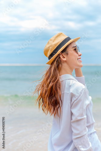 smiling young woman in sun hat and waring sun glasses on the  beach. summer, holidays, vacation, travel concept