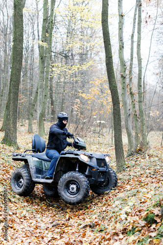 Travel without roads. ATV. A man rides through the forest on an all-terrain vehicle. Quad bike. In the woods. ATV trip to the forest