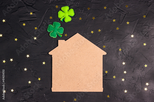 Fotografía Lucky home symbol with four-leaf clover on black background with stars