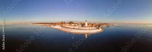 Panoramic view at the lighthouse of Urk Flevoland Netherlands, Urk during winter with white snow covered the beach. Winter in the Netherlands photo