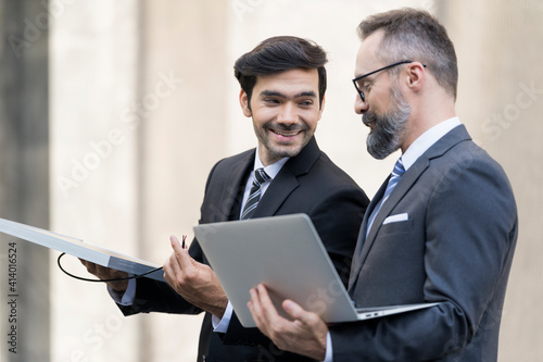 handsome businessman and attractive Engineer talking and holding laptop and solar panel.
