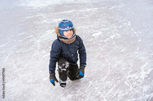 Obraz na plátně cute caucasian preschooler boy learn to skate on ice rink