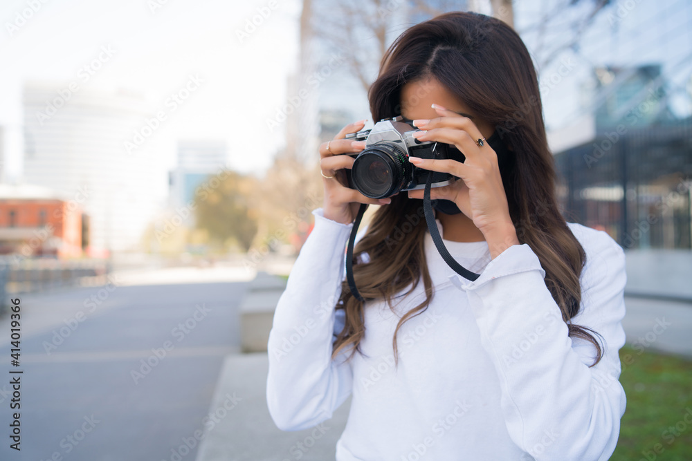 Young woman using a professional camera.