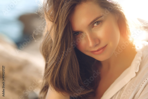 Beautiful woman. Young girl with rays of sunset bill. Portrait. High quality photo.