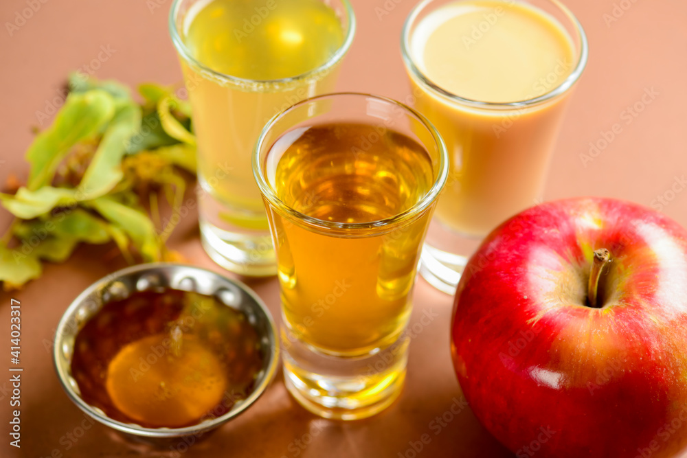 Fresh organic apple cider with apples and cinnamon over patel brown background. Close up three glasses. Fresh organic apple cider with apples and cinnamon over patel brown background. Close up three glasses.