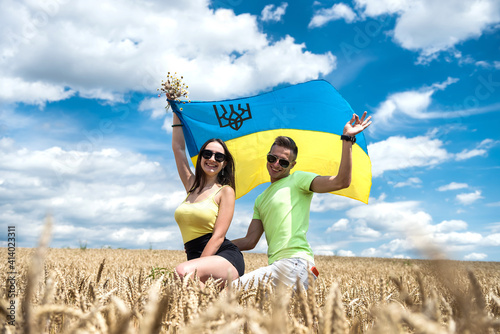molda happy couple with flag of ukraine in wheat field photo