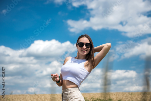 portrait of young smiling woman standing in wheat field