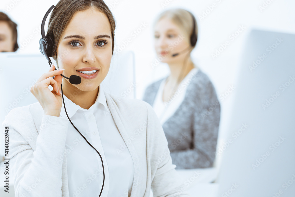 Call center. Group of diverse operators at work. Beautiful woman in headset communicating with customers of telemarketing service. Business concept Call center. Group of diverse operators at work. Beautiful woman in headset communicating with customers of telemarketing service. Business concept