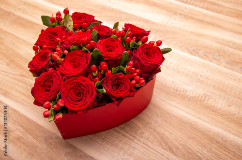 red roses in heart shape box on the table. space for text