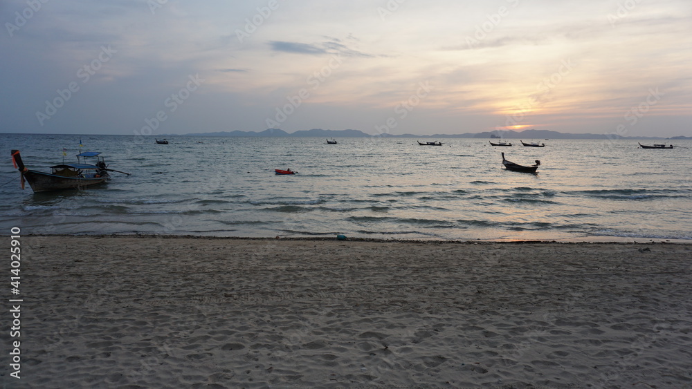 Fototapeta premium sunset and boats at the Khlong Muang Beach in Nong Thale, Krabi, Southern Thailand, March