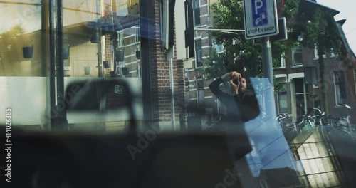 View from a inside a car of a man taking photos 