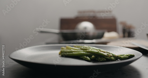 put roasted asparagus on black plate