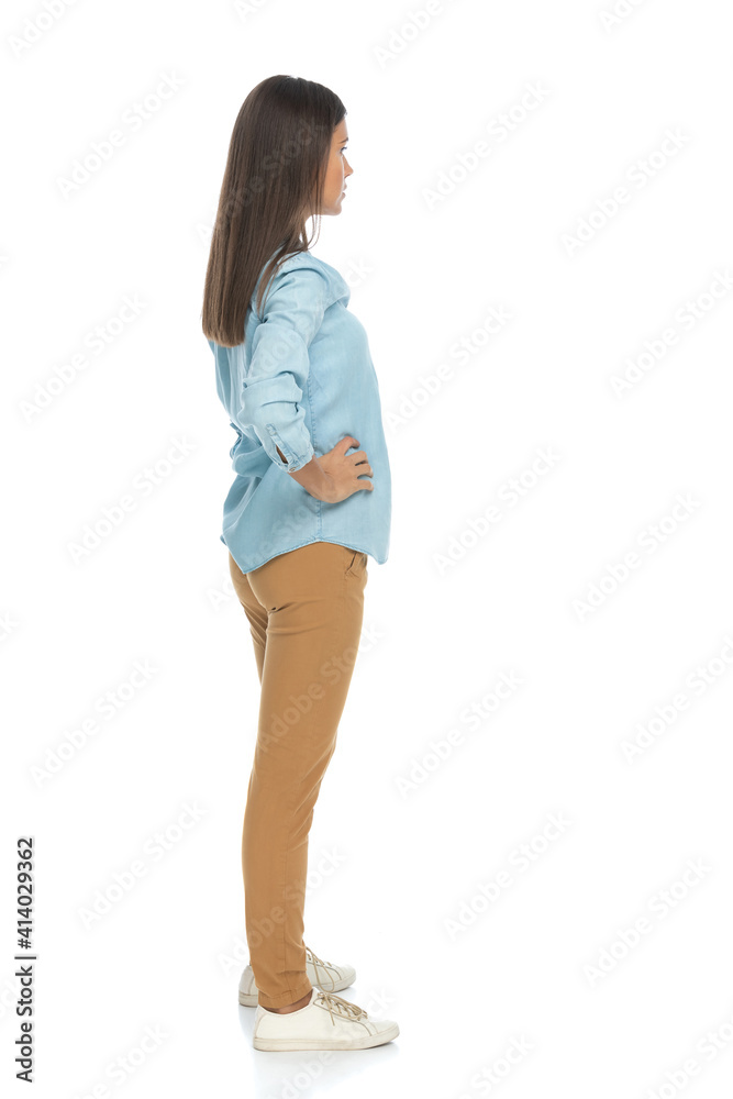 casual woman waiting in line with hands on her hips casual woman waiting in line with hands on her hips