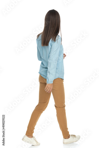 young casual woman walking one way and looking the other