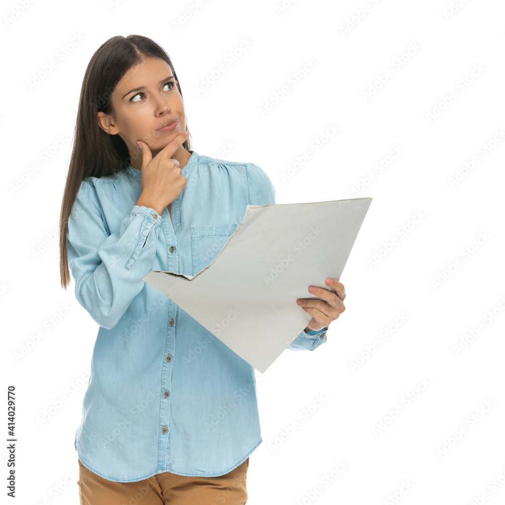 casual woman thinking about something she read on the newspaper casual woman thinking about something she read on the newspaper